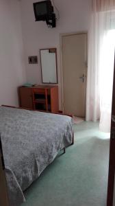 um quarto com uma cama, uma televisão e uma janela em Hotel Promenade em Milano Marittima