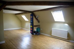 an empty room with two windows and a cat sitting in the corner at Bank House B&B in Bishops Castle