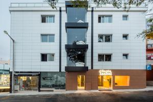 un grand bâtiment blanc avec une façade de magasin dans l'établissement Hotel Santa Isabel, à Fátima