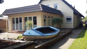 een blauwe boot voor een huis bij Ferienwohnung Ostseenähe in Hirschburg