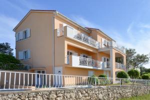 un grande edificio con balconi bianchi e recinzione di Cecilia Apartments a Lun