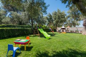 a yard with a playground with a table and chairs at Villa Elisabeth in Perama