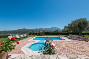 a swimming pool in a yard with mountains in the background at Villa Elisabeth in Perama