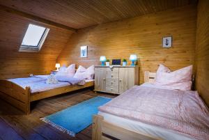 a bedroom with two beds and a wooden wall at Narnia Relax House - Liptov in Liptovský Mikuláš