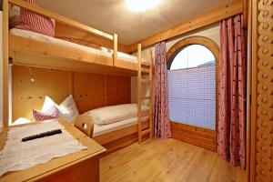 リート・イム・ツィラータールにあるLandhaus & Apartment Taxachのベッドルーム1室(二段ベッド2台、窓付)が備わります。