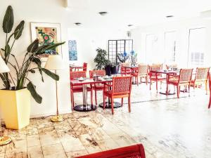 a dining room with tables and chairs and plants at Hotel Kölner Hof in Dormagen