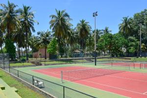 una pista de tenis con palmeras al fondo en Hôtel Sarakawa en Lomé