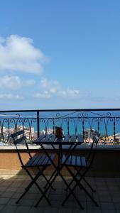 a table on a balcony with a view of the ocean at LES BIJOUX Apartments in Pietra Ligure