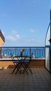 a table on a balcony with a view of the ocean at LES BIJOUX Apartments in Pietra Ligure