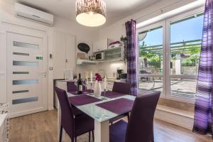 a dining room with a table and chairs and a window at Apartments Lavanda & Rozmarin in Split