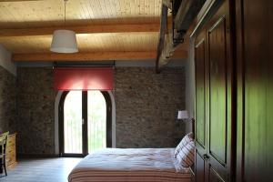 a bedroom with a bed in a room with a window at Casanova de Baix in Ripoll