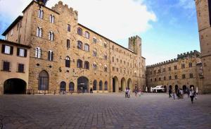 a large building with people walking in front of it at Suite Apartment Castello in Volterra