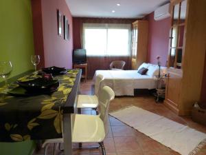 a hotel room with a bed and a table and chairs at Casco Viejo Candeleda in Candeleda