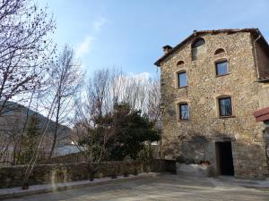 un antico edificio in pietra con un muro di pietra di Casanova de Baix a Ripoll