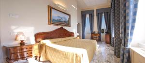 a bedroom with a bed and a dresser and window at Villa Angelina in Massa Lubrense