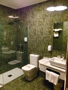 a bathroom with a toilet and a sink and a shower at Hotel Rural Peñalabra in Cervera de Pisuerga