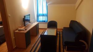 a room with a desk with a computer and chairs at Hotel Cubic in Laktaši