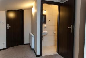 a bathroom with a toilet and a sink and two doors at Villa Pallas in Gdańsk