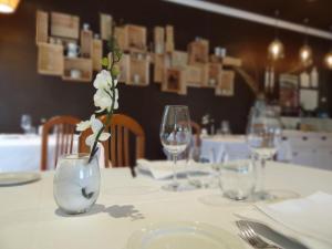 a table with glasses and a vase with flowers in it at Zezilionea in Olaberría