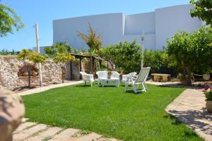 a yard with a table and chairs on the grass at Guest House Al Giardino dei Limoni in Favignana +27 photos