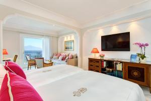 sypialnia z dużym białym łóżkiem i salonem w obiekcie Grand Hotel Royal w Sorrento