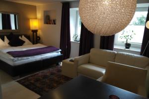 sala de estar con cama y lámpara de araña en Pension Leichtfried, en Amstetten