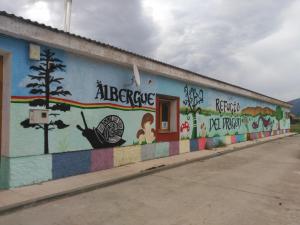 uma parede com um mural na lateral de um edifício em El Refugio del Dragón em Arcones