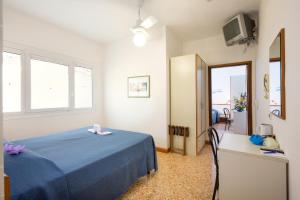 a bedroom with a blue bed and a mirror at Hotel Maxim in Caorle