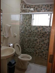 a bathroom with a toilet and a sink and a shower at Pousada Renascer II in Cachoeira Paulista
