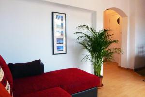 ニースにある"Le Tango": apartment with terrace, beach at 10 minutesの赤いソファと植物のあるリビングルーム