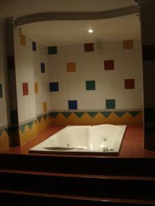 a bath tub in a room with colorful tiles at Hotel Sandiego inc in Barranquilla