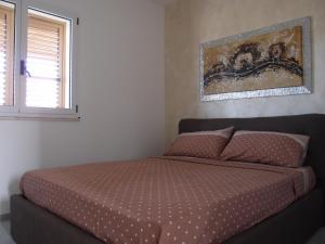 ラグーザにあるSulle tracce di Montalbanoのベッドルーム1室(ベッド1台付)が備わります。壁には絵画が飾られています。