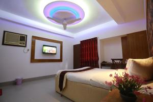 a bedroom with a bed and a tv on the wall at Nagar Valley Hotel Ltd. in Dhaka