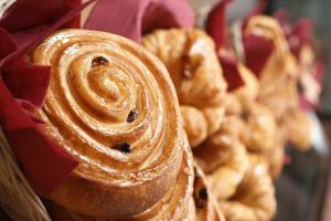 a person holding a loaf of pastries in a basket at Hotel Les Neus in Pas de la Casa