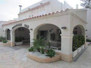 a building with a hotel with plants in front of it at Hotel Llorca in Platja de l’Almadrava
