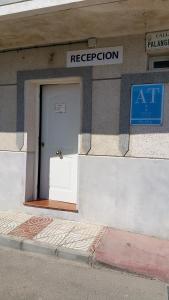 uma porta ao lado de um edifício com uma placa em Apartamentos El Galán em Carboneras