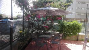 una mesa y sillas bajo una sombrilla en el balcón en B&B Max en Messina