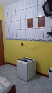 una pequeña estufa en una habitación con una pared amarilla en Pousada Da Restinga, en Cabo Frío