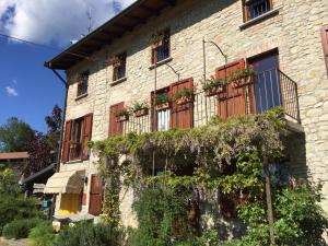 an old stone building with a balcony and plants at Agriturismo Spizzirò in Ponte Nizza