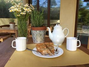 a plate of food on a table with two mugs at Agriturismo Spizzirò in Ponte Nizza