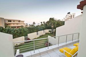 einen Balkon mit gelben Kissen auf einem weißen Gebäude in der Unterkunft D3 Sea Lodge - by Stay in Umhlanga in Durban