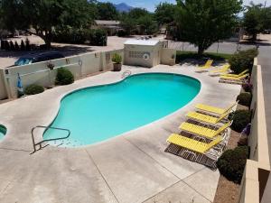 ein leerer Pool mit Liegestühlen um ihn herum in der Unterkunft Kingman KOA in Kingman