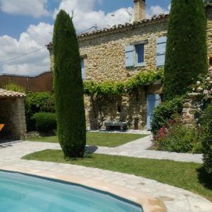 a house with a large tree next to a swimming pool at La Grange in Cruis