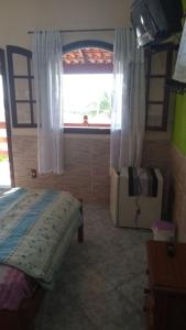 a bedroom with a bed and a window at Pousada Da Restinga in Cabo Frio