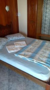 a bed with blue sheets and a wooden head board at Pousada Da Restinga in Cabo Frio