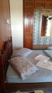 two twin beds in a room with a mirror at Pousada Da Restinga in Cabo Frio