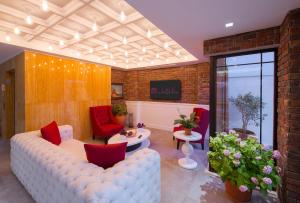 a living room with a white couch and red chairs at Lale Hotel in Kaş