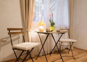 a table and two chairs in a room with a window at Cute Apartment For You in Zagreb