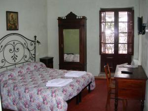 1 dormitorio con cama, mesa y espejo en Bed and Breakfast Via Della Piazza, en Pescasseroli