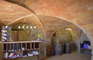 a room with a brick wall and a shelf with wine barrels at Hotel & Golf Ca La Caputxeta in Castelló d'Empúries +43 photos